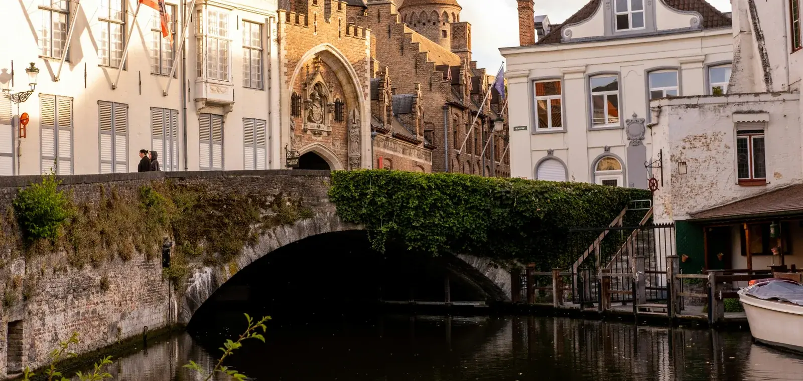 Een stille gracht bij de Gruuthusebrug in Brugge in avondlicht, vrijwel zonder mensen