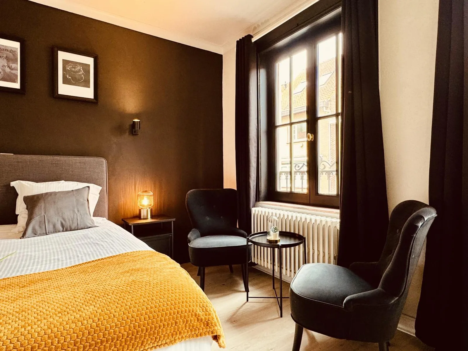 The two armchairs with a small table by the window in The Cozy Double Room