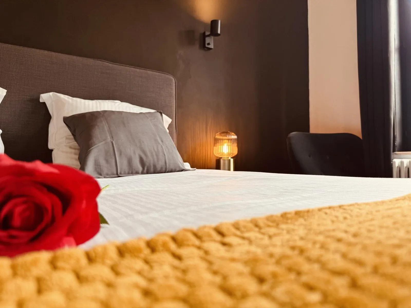 A red rose on the bed in The Cozy Double Room