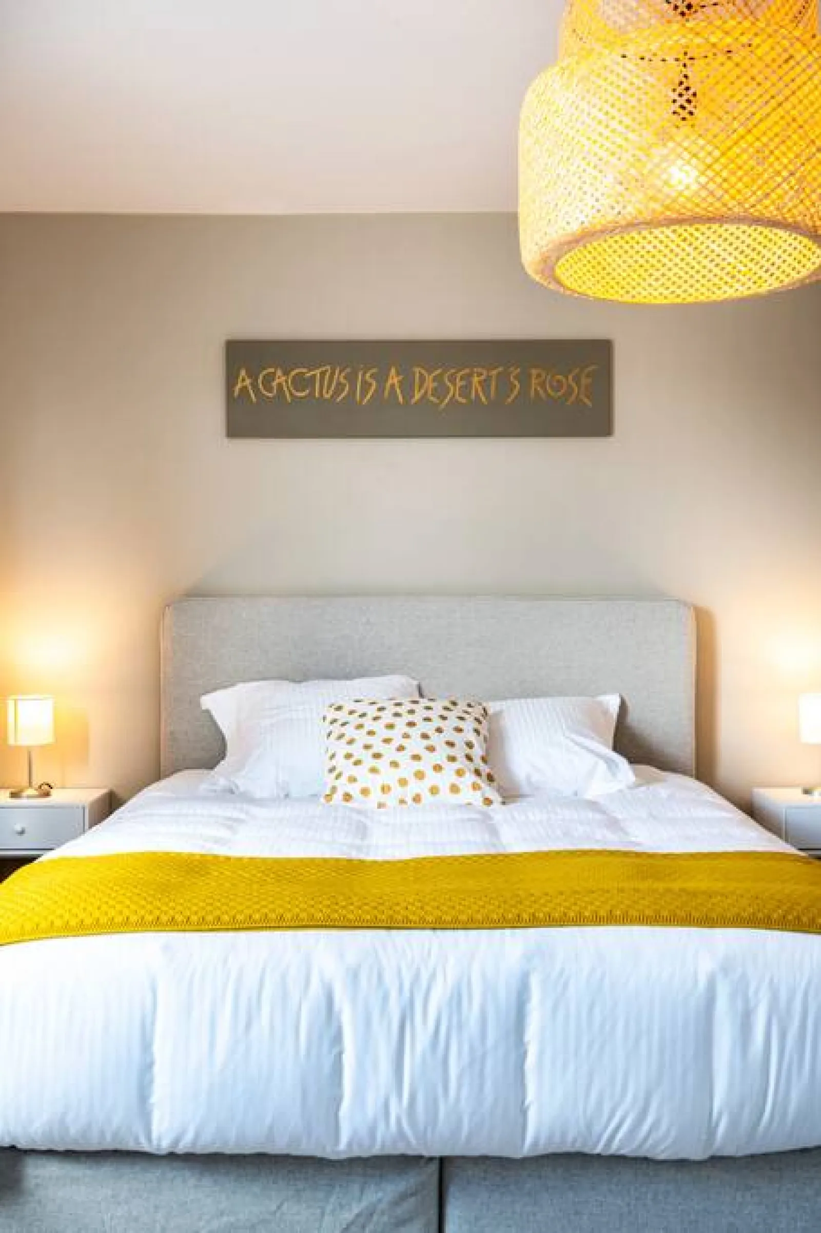A double bed in The Desert Rose, with the bedside table and the plant
