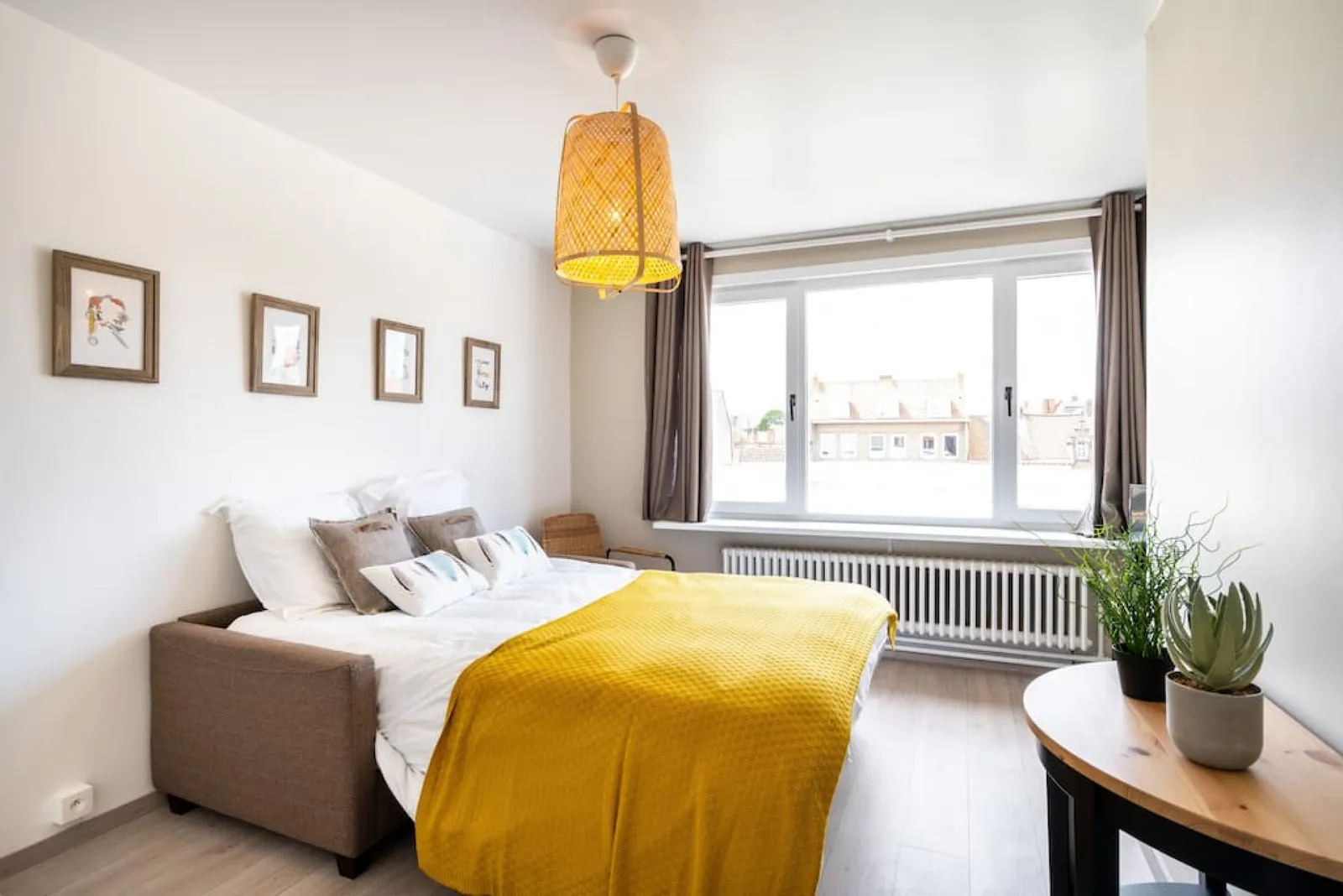 A double bed by the window in The Desert Rose, with the side table