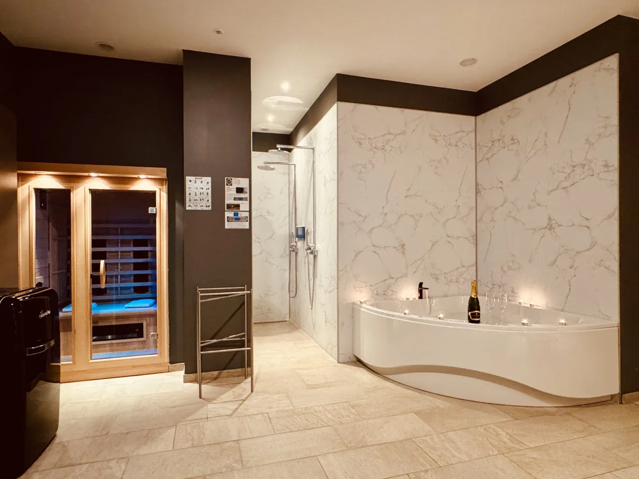 La Private Wellness Suite: la sauna de infrarrojos y la esquina del jacuzzi en la sala wellness de mármol